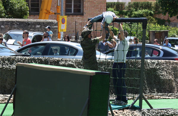 Un niño recibe ayuda en la pista de obstáculos