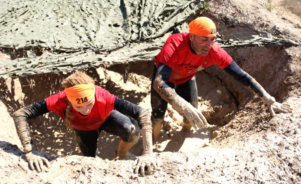 Participantes en la carrera salvan un obstáculo