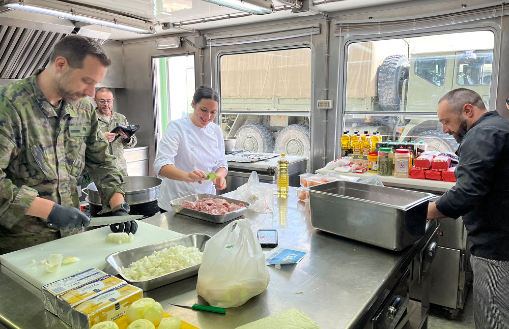 La cocinera y los militares elaboran el menú