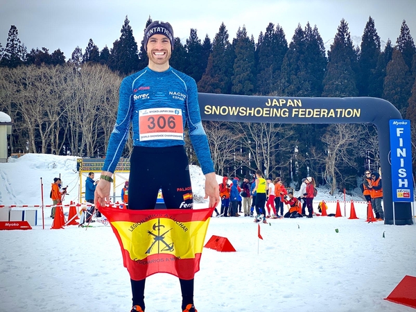 El nuevo Campeón del Mundo de Cross con raquetas de nieve, Nacho Hernando Angulo, exhibe la Bandera de mochila de La Legión , en Ikenotaria, Japón. 