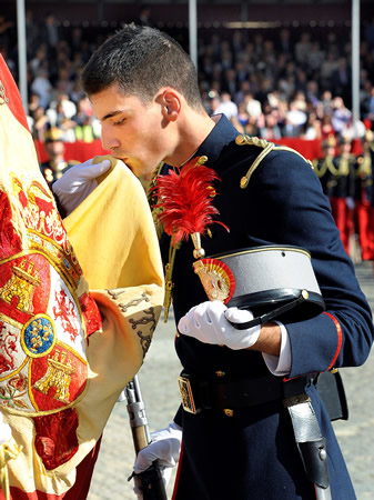 A cadet kisses the Flag with deep emotion.