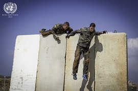 Paso de dos participantes de una patrulla por el muro