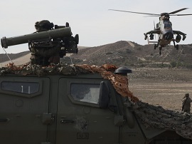 Vehículo de la BRILAT junto a un helicóptero Tigre