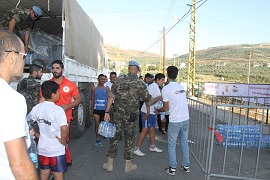 Personal del GTLP ayudado por voluntarios de la organización bajando agua del Camión